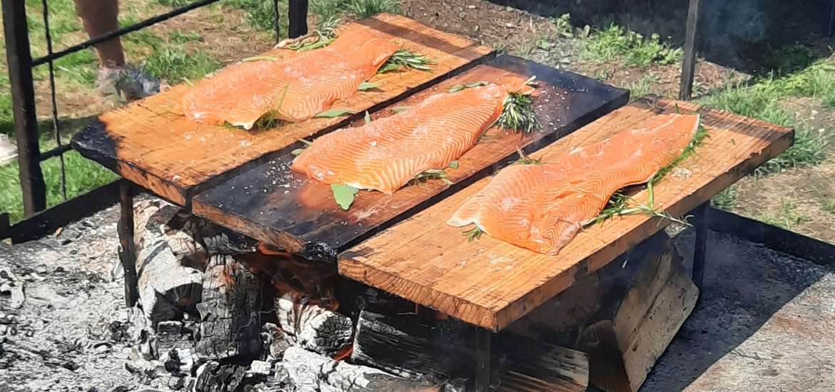 Fire and Feast - salmon cooking over smoking fire