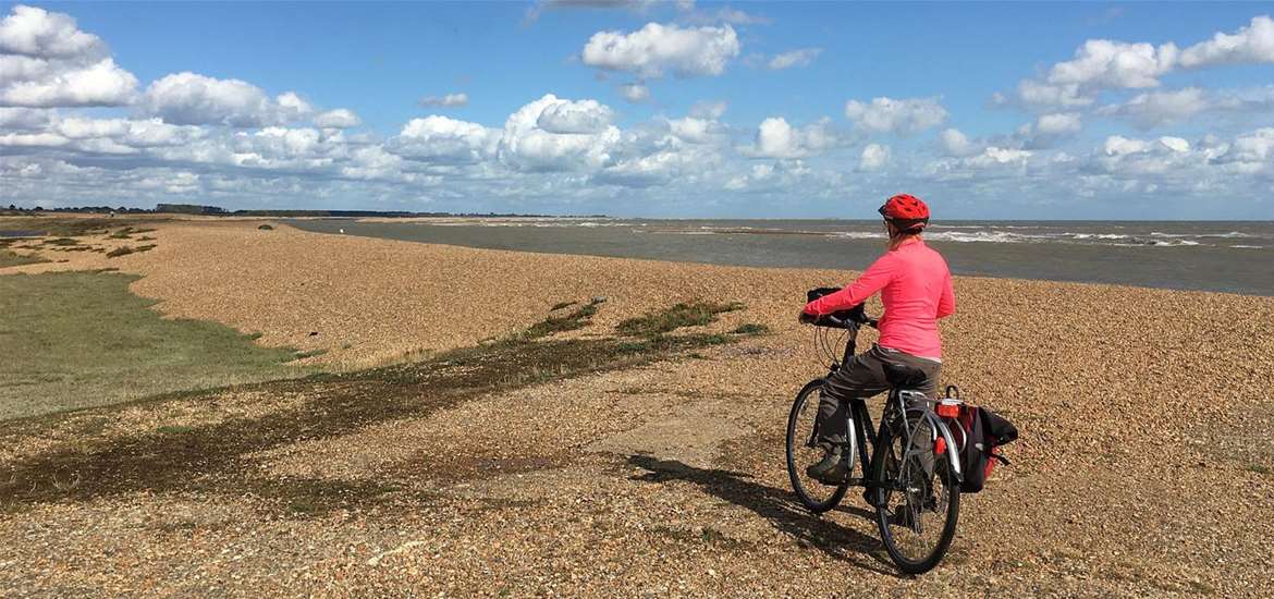 Touring cyclist at Shingle Street Suffolk