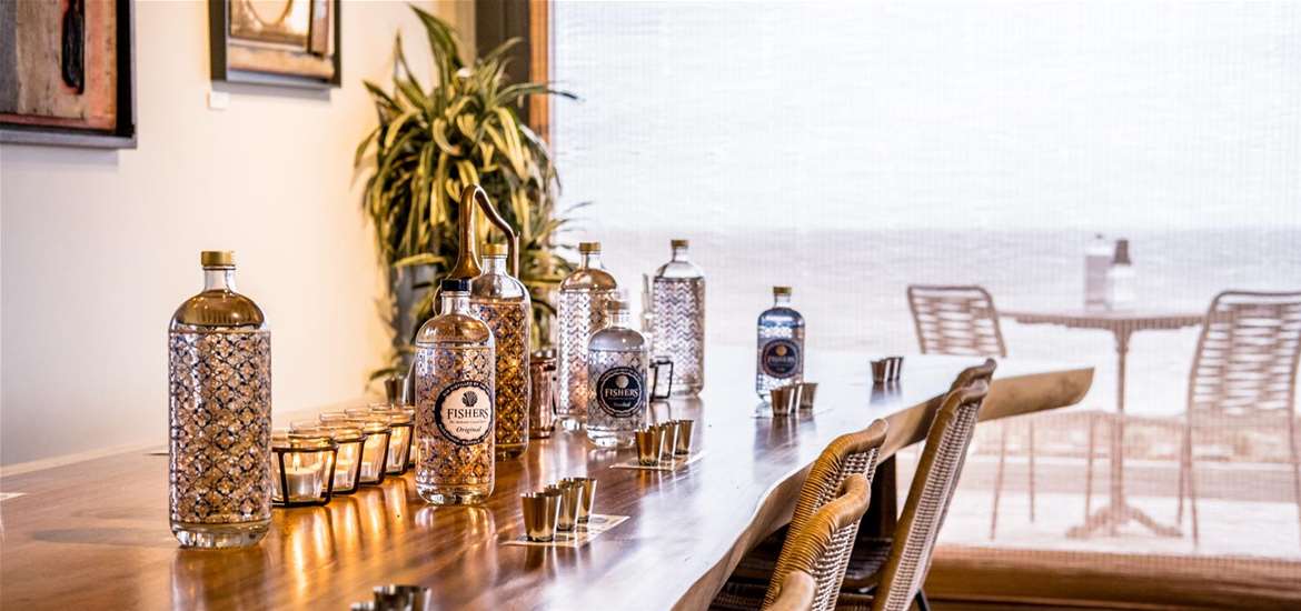 FD - Fishers Gin - Bottles on table in front of sea view