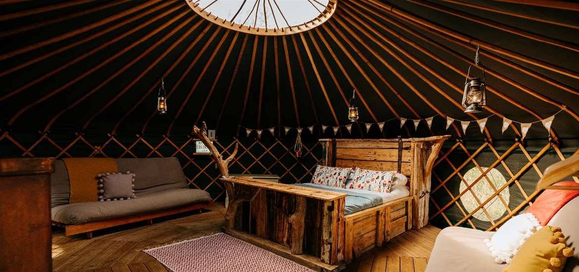 WTS - Suffolk Yurt Holidays - Yurt interior with bed, couch and skylight