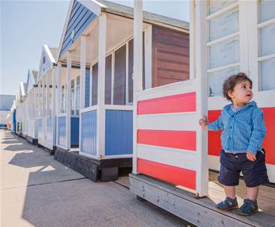 Child in front of beach huts at Southwold