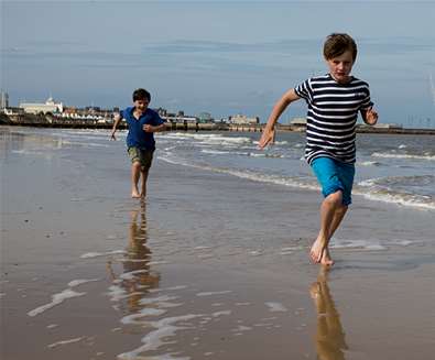 Boys running on beach at Lowestoft